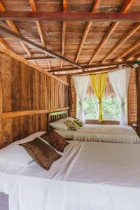 2 camas en una habitación con paredes de madera en Magic Green Dentro del Parque Tayrona en El Zaino