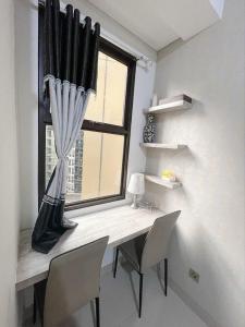 Zimmer mit einem Schreibtisch mit Stühlen und einem Fenster in der Unterkunft apartemen transpark cibubur by trend property in Kalimanggis