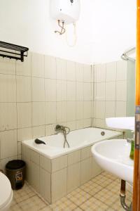 a bathroom with a bath tub and a sink at Hotel Green Prundi in Labuan Bajo +37 photos