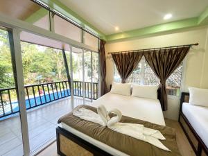 a bedroom with two beds and a balcony at Koh Mook Garden Beach Resort in Koh Mook