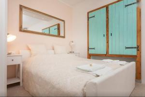 a bedroom with a white bed and a mirror at Studio Stella in Rovinj