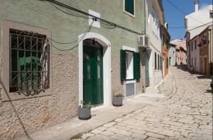 an alley with a green door on a building at Studio Stella in Rovinj