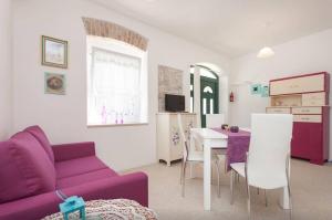 a living room with a purple couch and a table at Studio Stella in Rovinj