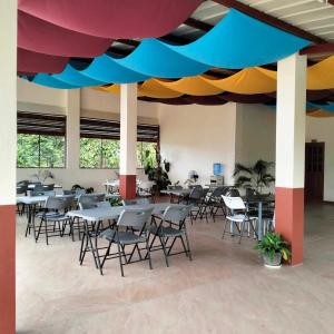 una cafetería con mesas y sillas bajo un techo colorido en Tessie's Home Stay Bed & Breakfast, en Puerto Princesa City