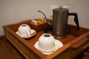 a wooden tray with two cups and a coffee pot at Kenran Resort Ubud By Soscomma in Ubud
