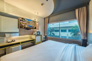 um quarto com uma cama grande e uma janela em Qiu Hotel Sukhumvit SHA Plus em Bangkok