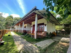 a house with a porch and a patio at Rainbow Sky Cottage in Ella