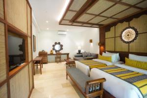 a hotel room with two beds and a television at Kenran Resort Ubud By Soscomma in Ubud