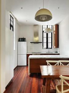a kitchen with a table and a white refrigerator at Shanghai Lane 里弄公寓 in Shanghai