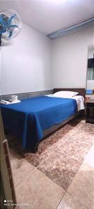 a bedroom with a bed with a blue blanket at Hostal 921 apocento in Arica