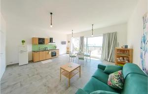 ein Wohnzimmer mit einem grünen Sofa und einer Küche in der Unterkunft 1 Bedroom Nice Apartment In Marzamemi in Marzamemi
