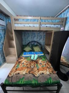 a bedroom with a bunk bed with a tiger pattern at Kachada Condotel Urban Deca Home in Manila