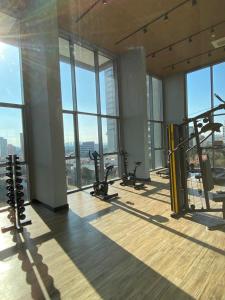 een sportschool met loopbanden en apparaten in een gebouw met ramen bij Studio Próximo ao metrô Butantã in Sao Paulo