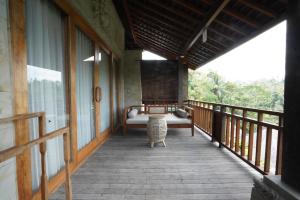 a porch of a house with a couch on it at Kenran Resort Ubud By Soscomma in Ubud