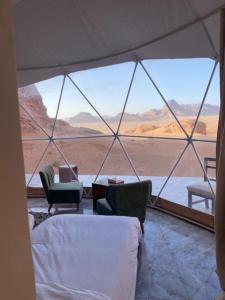 a room with a view of the desert from a tent at Wadi Rum living camp in Wadi Rum