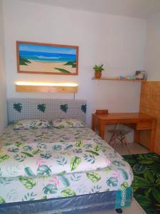 a bedroom with a bed and a wooden desk at Aloha Living in Pangandaran