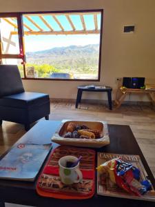 a table with a tray of food and a cup of coffee at Hacienda La Cabrera Huacalera in Huacalera