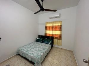 1 dormitorio con 1 cama y ventilador de techo en AA Burger Homestay for Musliim Only en Banting