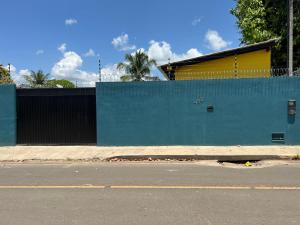 a building with a blue wall next to a street at APARTAMENTO MOBILIADO in Boa Vista