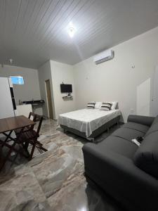 a bedroom with a bed and a couch and a table at APARTAMENTO MOBILIADO in Boa Vista