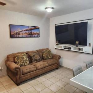 uma sala de estar com um sofá e uma grande televisão de ecrã plano em 3 bedroom townhouse w garage blocks from the beach em Puerto Peñasco