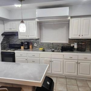 uma cozinha com armários brancos e um lavatório em 3 bedroom townhouse w garage blocks from the beach em Puerto Peñasco