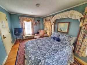 a bedroom with a bed with a blue comforter at Montague Inn Bed & Breakfast in Saginaw