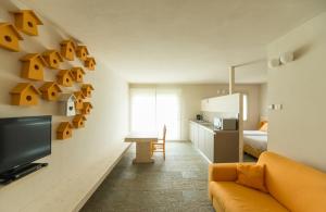 un soggiorno con divano e TV e una cucina di Quader nidi nel verde a Bienno
