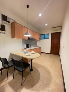 a kitchen with a table and chairs in a room at Cozy 1 Bedroom Condo w Balcony in Shah Alam