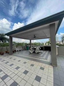 a patio with a blue roof with chairs and tables at Cozy 1 Bedroom Condo w Balcony in Shah Alam