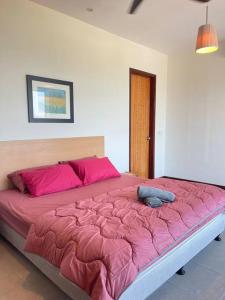 a bedroom with a large bed with pink sheets at Cozy 1 Bedroom Condo w Balcony in Shah Alam