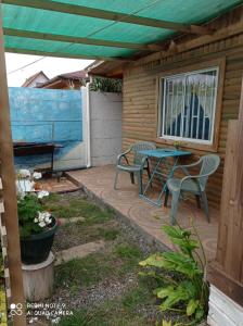 eine Terrasse mit 2 Stühlen, einem Tisch, einem Tisch und einer Bank in der Unterkunft Mini Loft in El Quisco