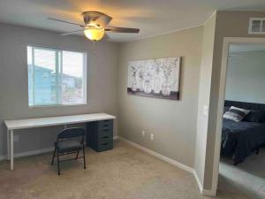 1 dormitorio con escritorio, 1 cama y ventana en *Your Colorado Escape*, en Commerce City