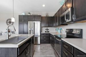 a kitchen with wooden cabinets and a stainless steel refrigerator at *Your Colorado Escape* in Commerce City