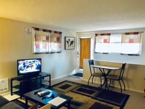 een woonkamer met een televisie en een tafel bij Emerald City Studio Suite in Eugene