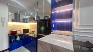 een keuken met blauwe kasten en een wastafel bij Apartemen Vida View Makassar by drAnca in Makassar