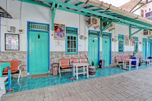 a building with blue doors and tables and chairs at Capital O 92929 Hotel New Tirta Kencana Syariah in Tegal