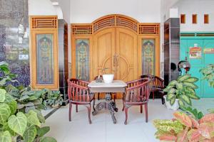 Pokój ze stołem, 2 krzesłami i drewnianymi drzwiami w obiekcie Capital O 92929 Hotel New Tirta Kencana Syariah w mieście Tegal