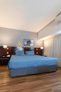 una camera da letto con un grande letto blu con lenzuola blu di ELEGANCE SUÍTES BERRINI a San Paolo