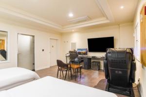 a hotel room with a bed and a desk with a tv at Carlton Hotel in Incheon