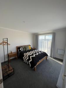 a bedroom with a bed and a large window at The Little Lake House in Te Anau
