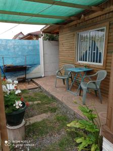 a patio with a table and chairs and a bench at Las 2 Golondrinas in El Quisco