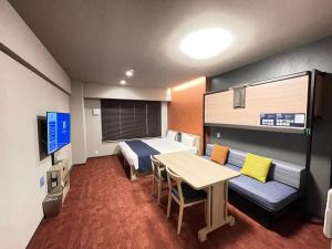 Habitación con cama, mesa y sofá en MONday Apart 日本橋水天宮前, en Tokio