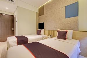 een hotelkamer met 2 bedden in een kamer bij Townhouse Oak IXO Hotel in Semarang