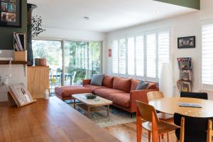 uma sala de estar com um sofá e uma mesa em Katoomba Falls Cottage em Katoomba