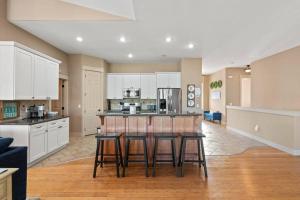 a kitchen with white cabinets and a bar with stools at Upscale Huge Home 2 Decks w Views 2 Living Rooms in Spokane