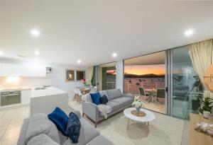 una sala de estar con un sofá y una mesa en Penthouse Oasis On Airlie, en Airlie Beach