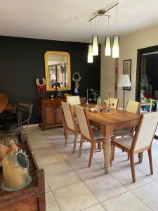 - une salle à manger avec une table et des chaises en bois dans l'établissement Michelle’s flat by the Sea, à Nouméa