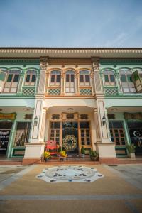 a large building with a clock on the front of it at O'nya Phuket Hotel - SHA Extra Plus in Phuket Town