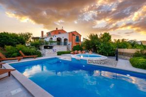 a swimming pool in front of a house at Vila Bonita in Klek